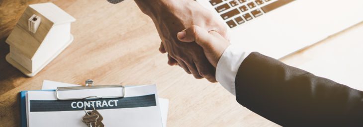 two people shaking hands across a table